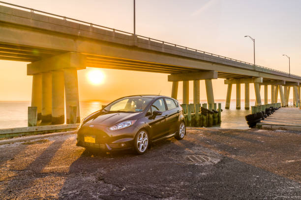 auto davanti a un ponte durante il tramonto - ford fiesta foto e immagini stock