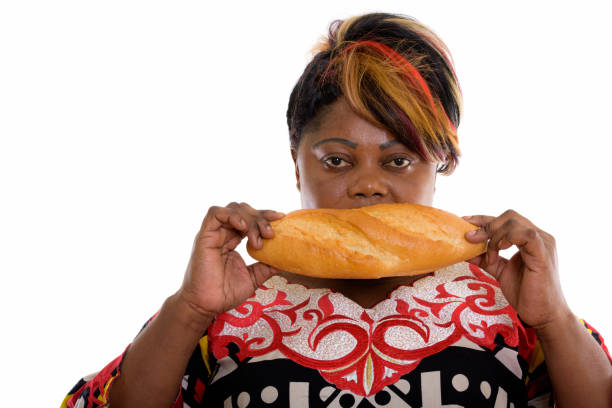 studioaufnahme von fette schwarze afrikanische frau brot essen - overweight headshot studio shot looking at camera stock-fotos und bilder