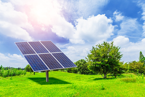 Solar panels on green grass with blue sky