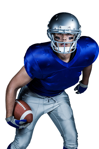 Portrait of American football player in uniform playing against white background