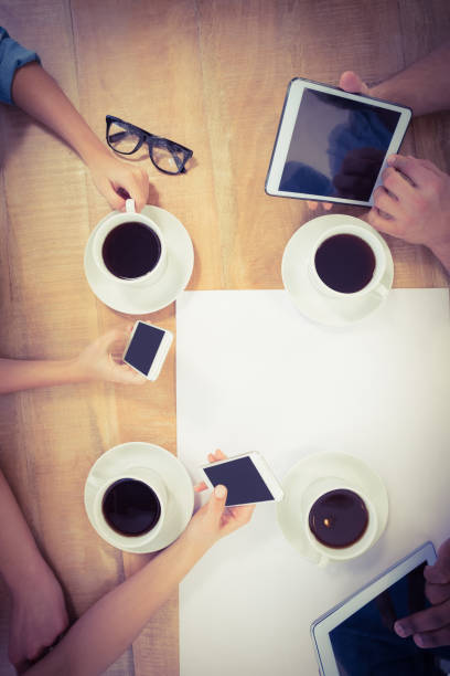 istock Overhead view of people using technology at desk 670665140