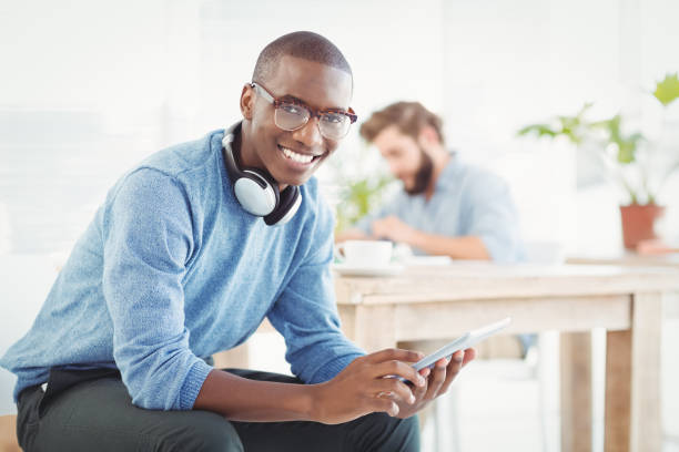 istock Portrait of smiling man with headphones while using digital tablet 670668196
