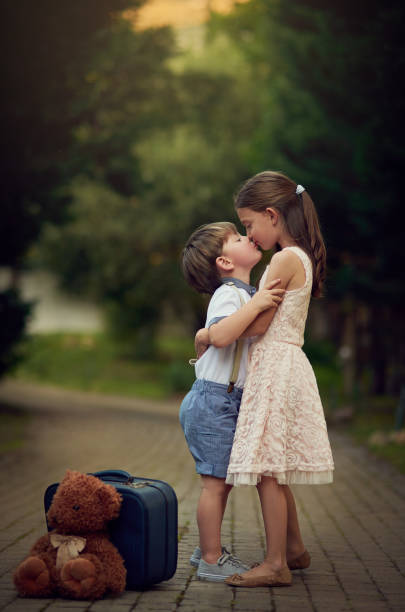 Shot of a cute little girl kissing her little brother while they play outside