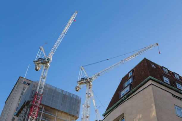 istock two large building constrction cranes operating against clear blue London sky 670684810