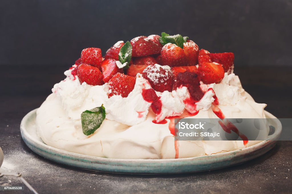 Delicious pavlova cake with strawberries and cranberry sauce Delicious pavlova cake topped with sweetened whipped cream, balsamic strawberries and cranberry sauce, selective focus Cranberry Stock Photo