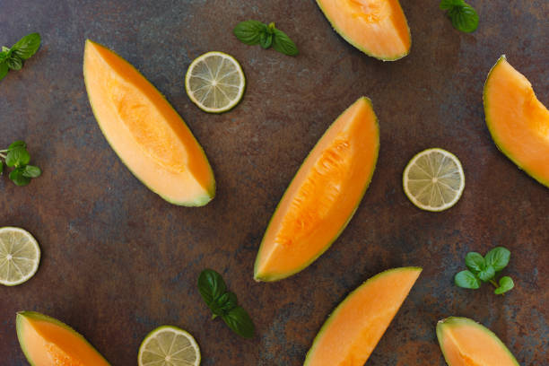 istock Slices of cantaloupe melon and lime on rustic dark background 670685968