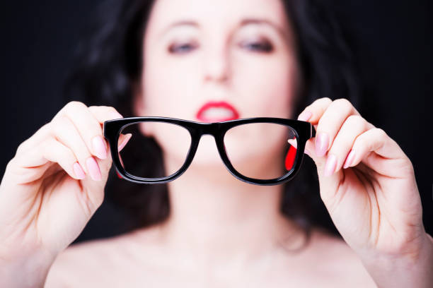 istock Young woman holding eyeglasses. 670692414