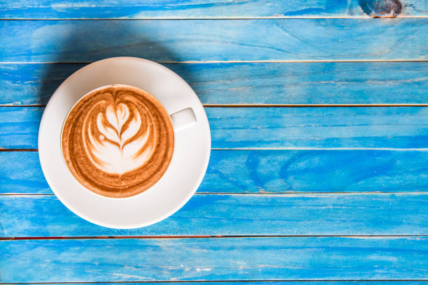 istock top view hot chocolate in cup on blue wooden table. 670701680