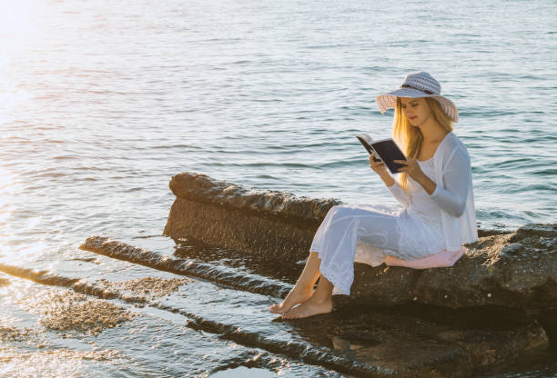 istock Reading a book on coastline with the perfect 670701750