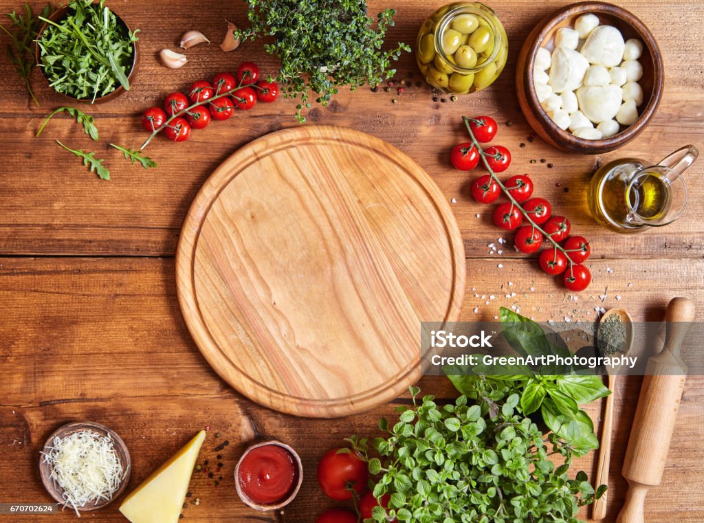 Planche en bois avec la traditionnelle pizza préparation ingridients : mozzarella, sauce tomate, basilic, huile d’olive, fromage, épices. - Photo de Pizza libre de droits