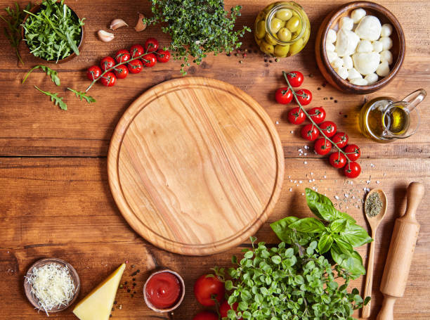 cutting wooden board with traditional pizza preparation ingridients: mozzarella, tomatoes sauce, basil, olive oil, cheese, spices. - mozzarella cheese italy tomato imagens e fotografias de stock