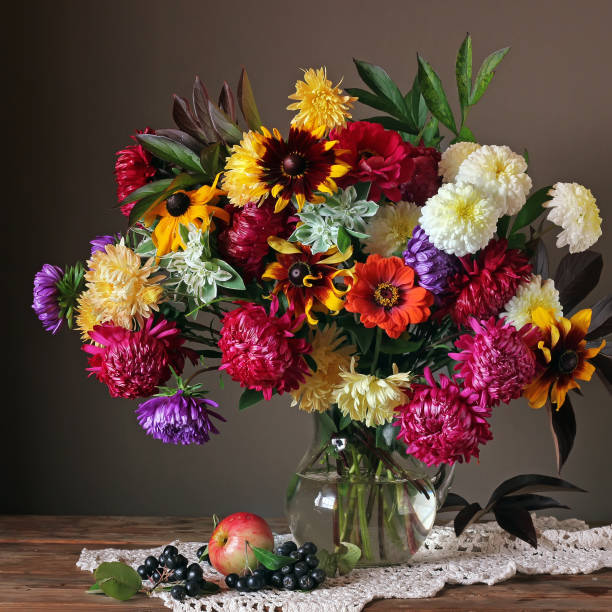 istock Still life with autumn flowers, apple and berries 670708380
