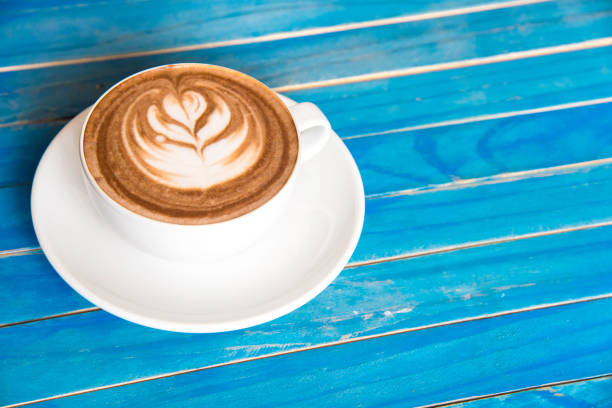 istock top view hot chocolate in cup on blue wooden table. 670709120