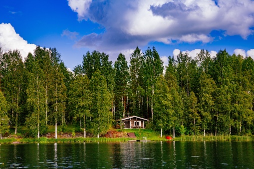 Wooden sauna log cabin at the lake in summer in rural Finland