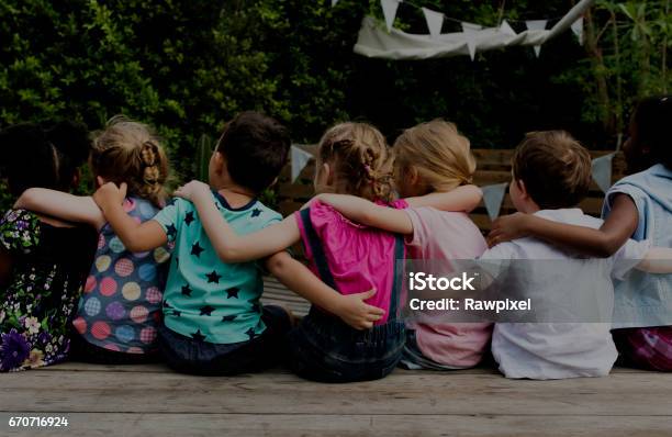 Group Of Kindergarten Kids Friends Arm Around Sitting Together Stock Photo - Download Image Now