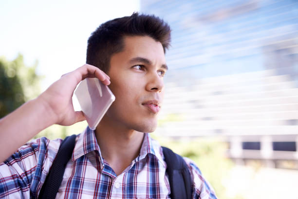 Cropped shot of a young man taking a break from his bike ride to make a phonecall