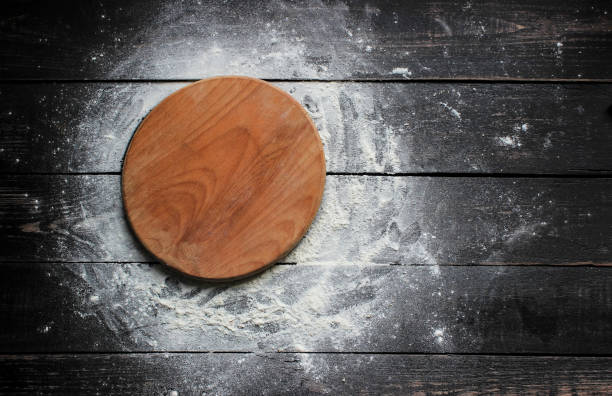 istock Cutting board with  flour on a kitchen wooden table 670726912