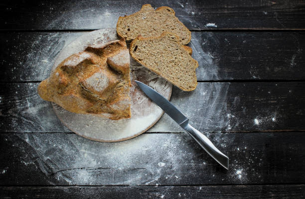 istock Freshly delicious bread with flour and knife on a rustic wooden table 670727370