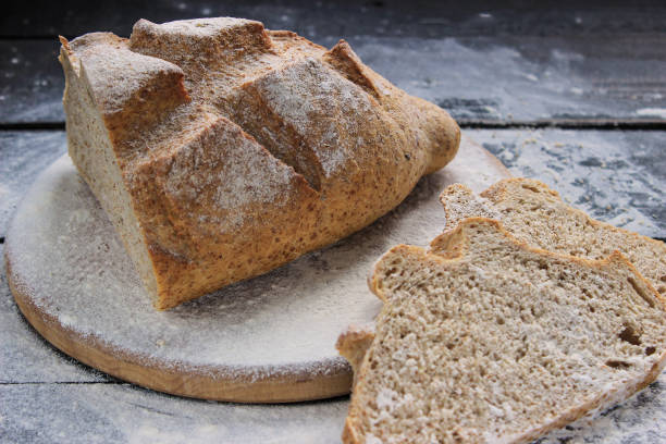 istock Freshly baked sliced bread on a cutting board . Rustic wooden table 670727378