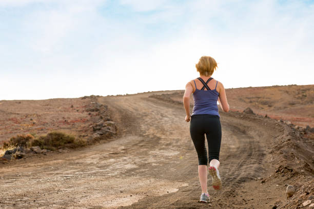 istock Woman Jogging on Dirt Trail 670731278