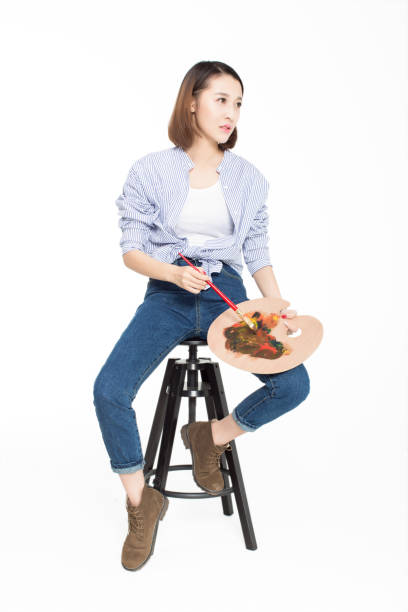 young beautiful painter holding a palette conceived a painting, isolated on white studio