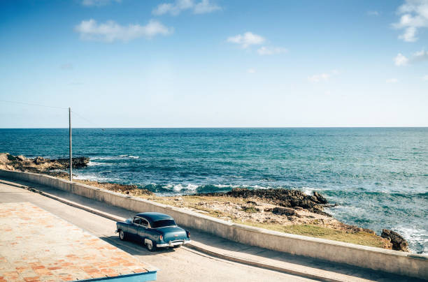 istock Old vintage car driving along coastline, Cuba 670740240