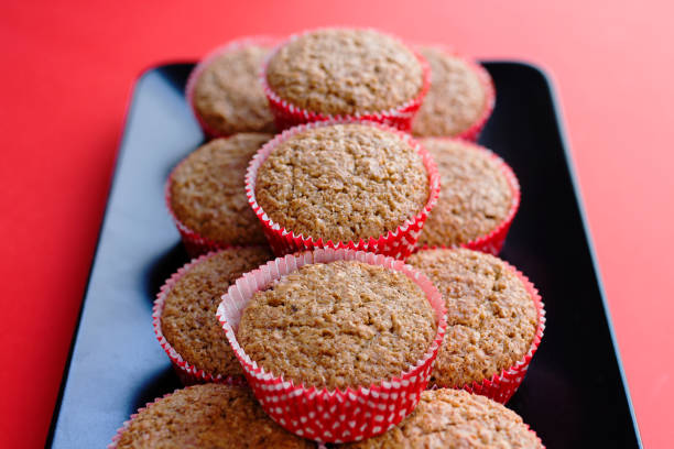 istock Bran muffins in bright red and white paper holders on a black rectangular plate 670743840