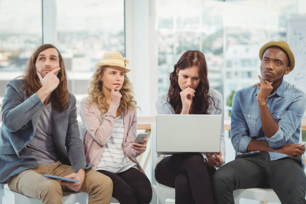 istock Thoughtful business people with hand on chin while sitting on chair 670743884