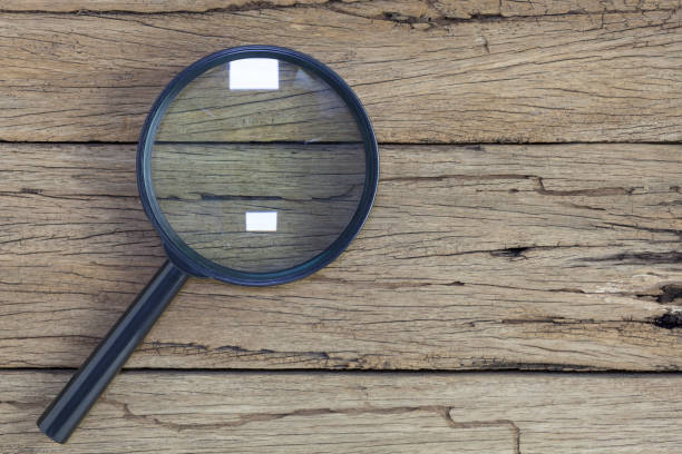 istock magnifying glass on old wooden table background. 670744108