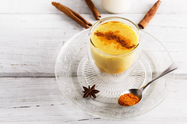 Golden latte over white wooden table stock photo