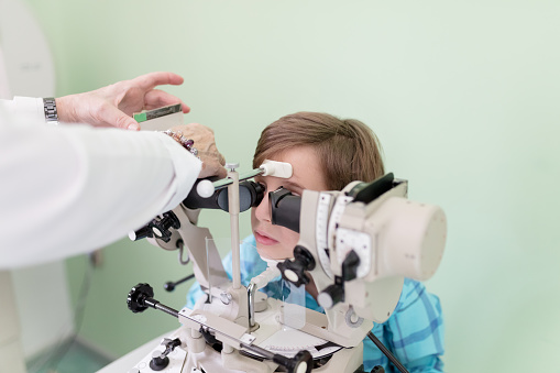 Boy at the eye doctor getting an eye exam