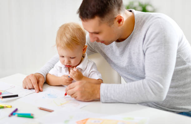 istock father and baby son paint together 670752404