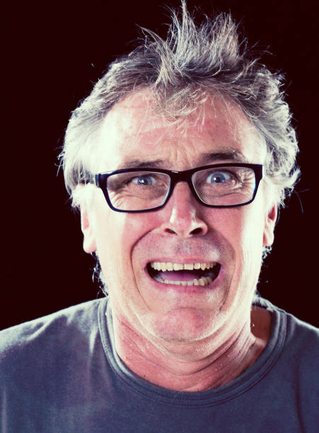 istock Frantic, deranged-looking mature man in glasses grimaces 670770478