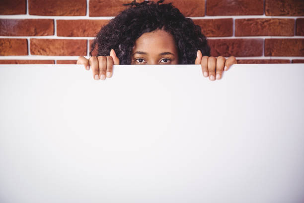 istock Smiling woman holding white board 670785784