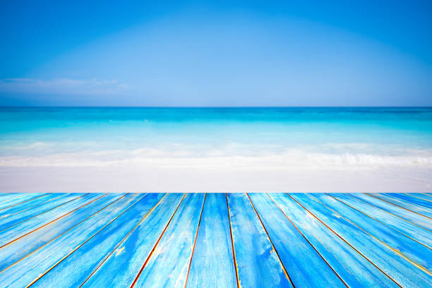 istock Blue wooden table top on blurred beach background 670786684