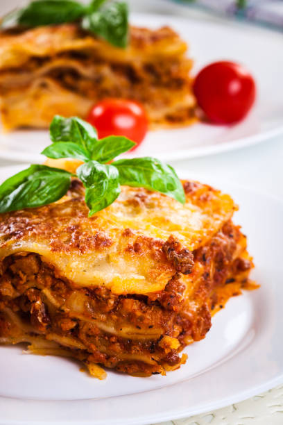 Piece of tasty hot lasagna with red wine stock photo