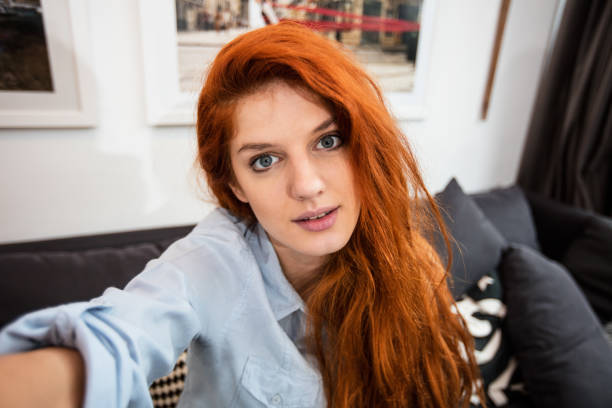 Sexy redhead with beautiful eyes taking selfie