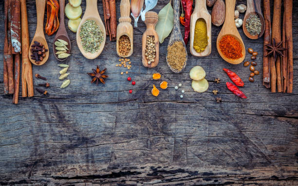 various of spices and herbs in wooden spoons. flat lay of spices ingredients chilli ,pepper corn, garlic, thyme, oregano, cinnamon, star anise, nutmeg, mace, ginger and bay leaves on shabby wooden. - chinese traditional medicine imagens e fotografias de stock