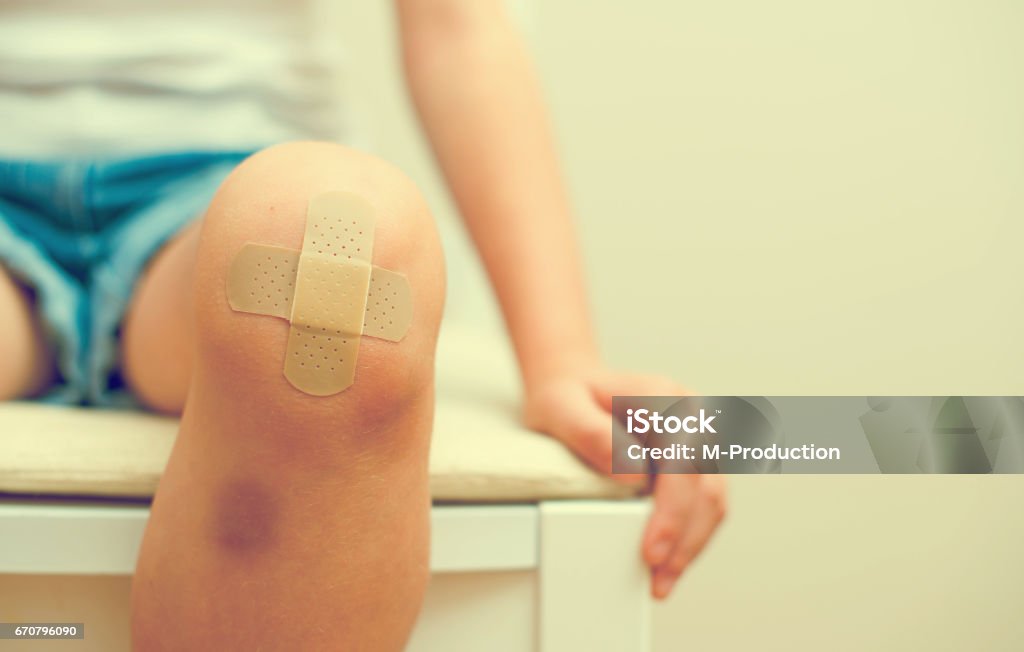 Child knee with an adhesive bandage and bruise. Child Stock Photo