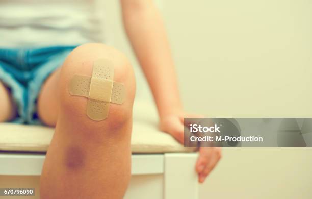 Child Knee With An Adhesive Bandage And Bruise Stock Photo - Download Image Now - Child, Physical Injury, Adhesive Bandage