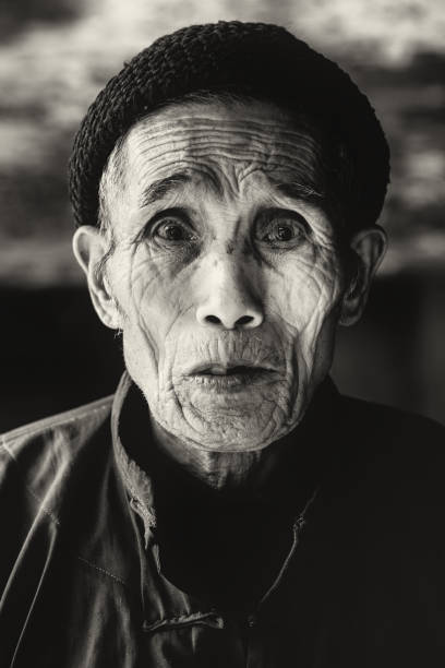 Old chinese senior man looking into the camera. BW Portrait. Slightly Sepia Toned. Real People Portrait. Zhao Xing, China