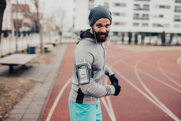 istock Athlete wearing warm clothes on the running track 670805758