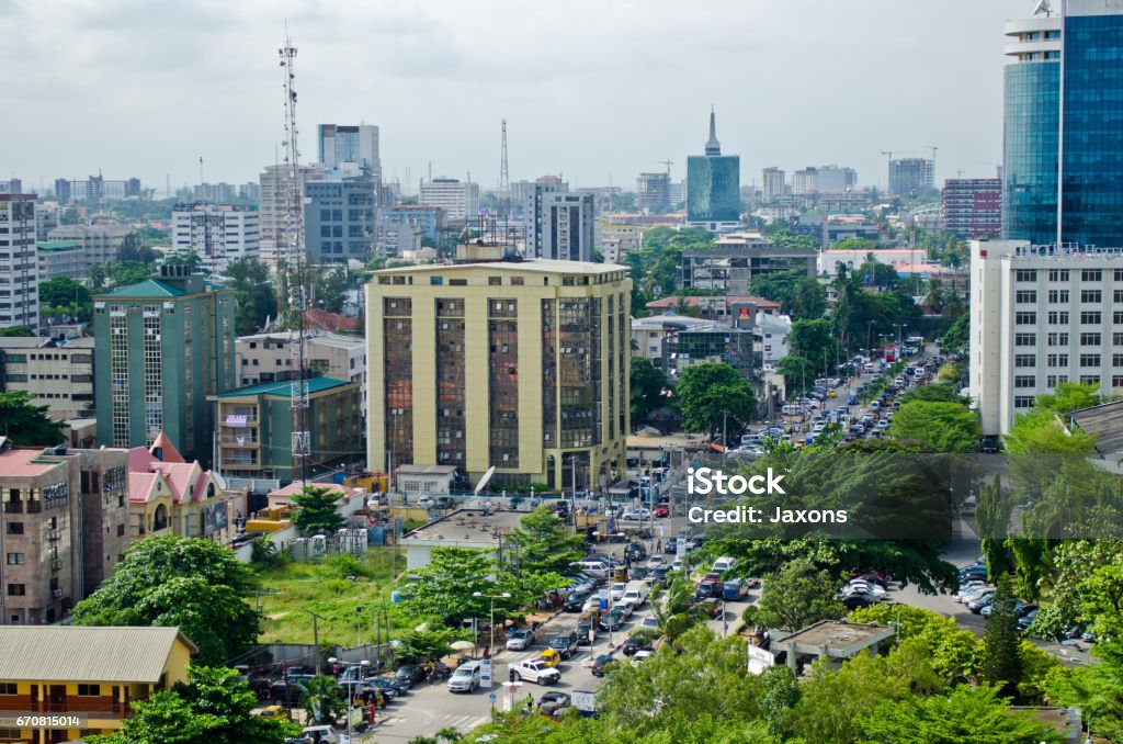 Tuk tuk drivers and other road users travel around the port city of Lagos Lagos, Nigeria - May 20, 2016: Tuk tuk drivers transport their passengers around the port city of Lagos on May 20, 2016 in Lagos, Nigeria. Lagos port is responsible for processing 80% of imports into Nigeria. Lagos - Nigeria Stock Photo