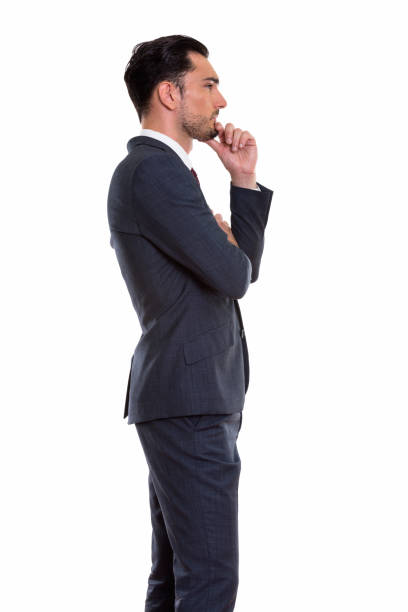 istock Profile view of young handsome businessman standing while thinking 670819228