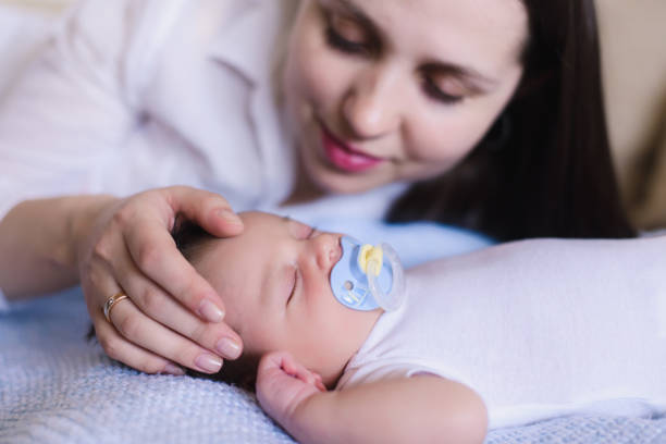 istock Mom gently stroking the babys head 670821606