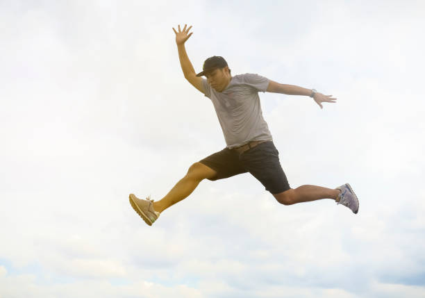 istock Young man happily jumping against blue sky. 670822476