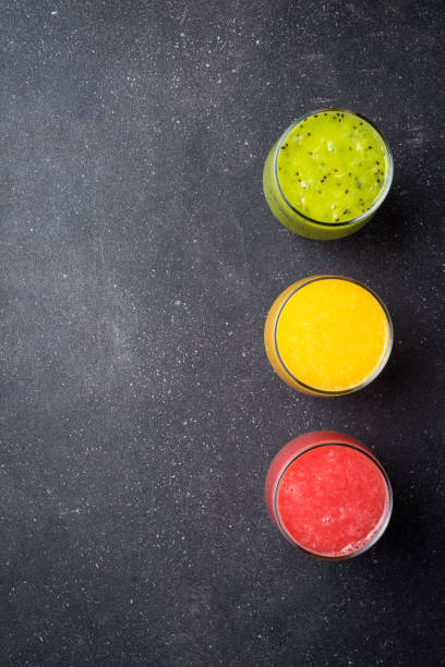 istock Glasses of juice on dark stone table. 670825706