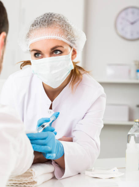 istock Female nurse injecting male patient 670829062