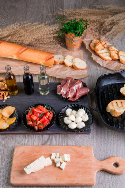 bruschetta de ingredientes para a preparação. antepasto de comida de cozinha italiana, crostini.
estilo rústico. - bruschetta cutting board italy olive oil - fotografias e filmes do acervo