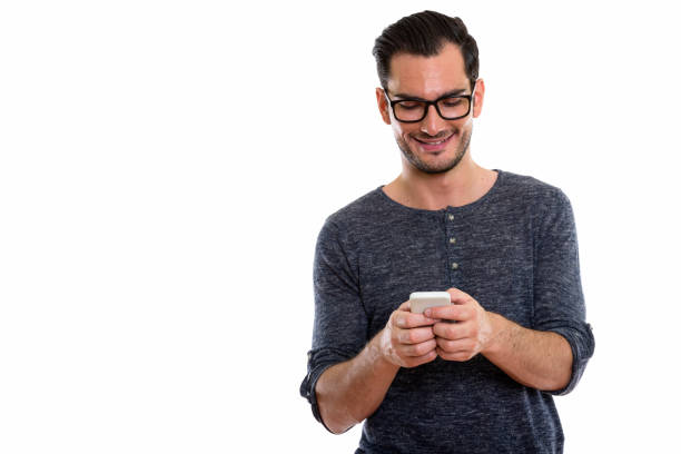 istock Studio shot of happy young handsome man smiling and using mobile phone while wearing eyeglasses 670835226